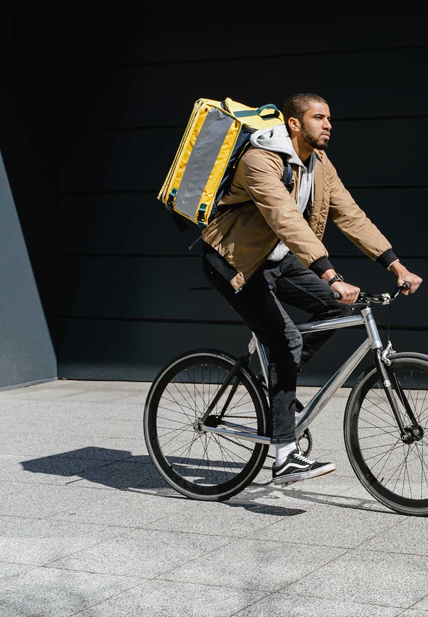 mann auf fahrrad mit großem rucksack